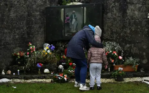 Reuters A mother and her daughter pay their respects at the Tuam graveyard where the bodies of 796 babies were uncovered