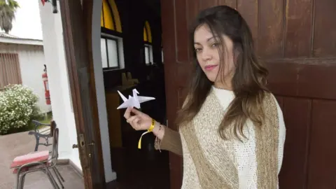 BBC Estefanía holds up a paper dove she has made as decoration for the Pope's visit