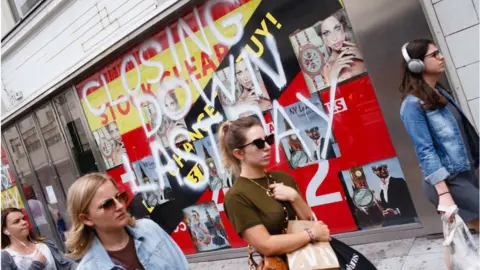 NurPhoto People walk past a closed down store in Oxford Street