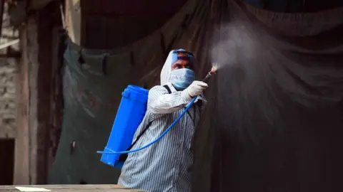 Hindustan Times A man disinfecting a neighbourhood