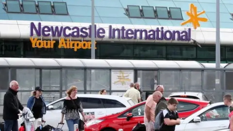 Newcastle Airport with travellers in the foreground