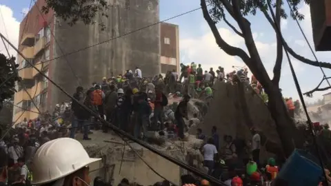 Manuel Mavroleon Aguayo People help emergency workers search for survivors