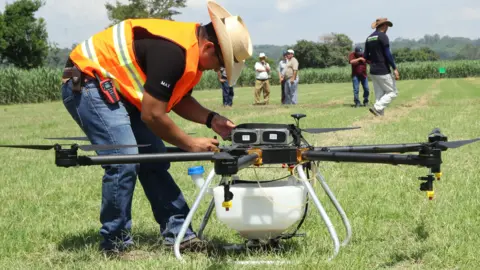 Hylio Man assessing crop-spraying drone