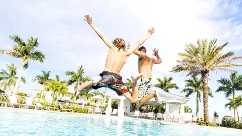 Getty Images Boys jumping into swimming pool