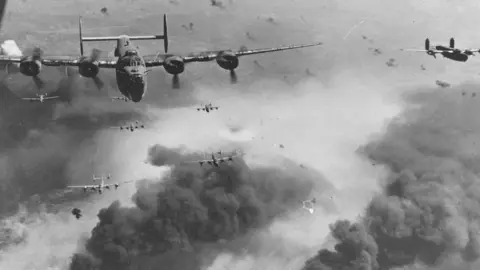 National Museum/PA Wire Aircraft flying above smoke and debris