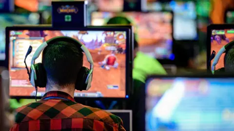 Getty Images A player plays world of Warcraft at an event with many PCs