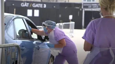 Medics conduct a test at a drive-through