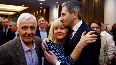 Reuters Simon Harris embracing his mother Mary with his father Bert