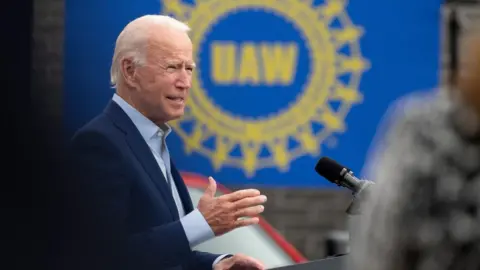 Getty Images Joe Biden in front of a UAW sign