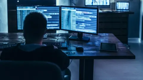 Getty Images A hacker at a computer in a dark room