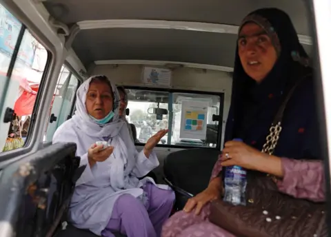 Reuters Two women waiting in an ambulance after being rescued from the hospital