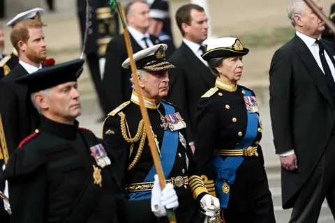 Getty Images King Charles III and Anne, Princess Royal follow behind The Queen's funeral cortege borne on the State Gun Carriage of the Royal Navy as it leaves Westminster Abbey on September 19, 2022 in London