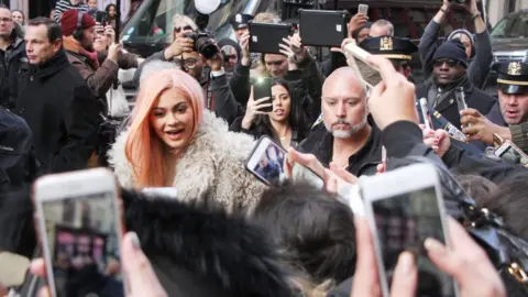 Shutterstock Jenner flanked by fans and security at a pop-up launch event in 2017 in New York