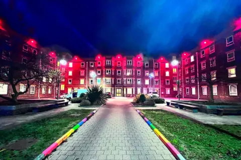 Nottingham University Hospitals City Hospital in the dark lit up with red lights