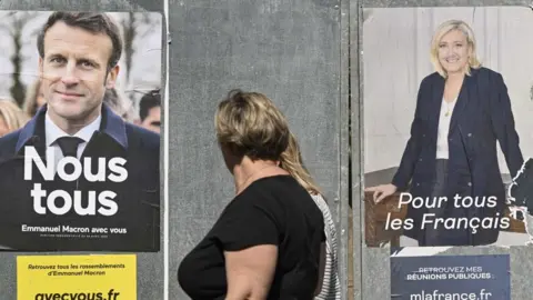 Getty Images Image shows Macron and Le Pen poster