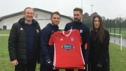 Managing director Ian Milne, players Joe Garner and Luke Chambers and Rosie Richardson, town's director of sales, holding the new away shirt