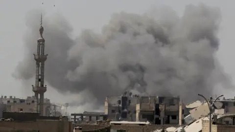 Reuters Smoke rises after an air strike during fighting between members of the Syrian Democratic Forces and Islamic State militants in Raqqa, Syria (20 August 2017)