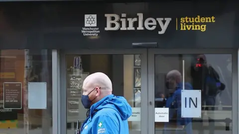 PA Media Man in mask outside block