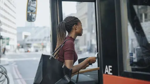 Getty Images Woman boarding bus