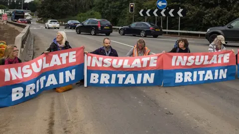 Getty Images Insulate Britain protesters blocking a busy road