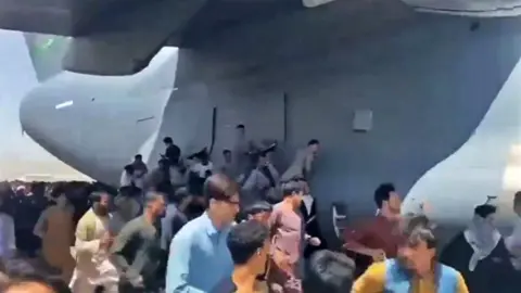 People trying to board USAF aeroplane at Kabul airport