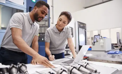 Getty Images Engineering workers operate CAD software at work