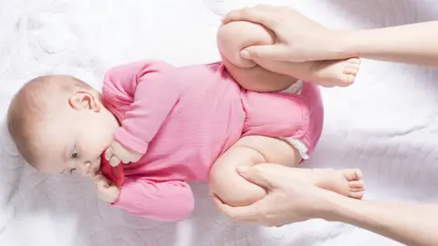 Getty Images Baby having its hips moved around