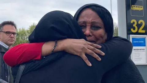 BBC Woman hugs sister at Stansted Airport after evacuation from Sudan