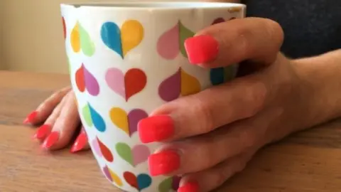 BBC Female hand holding cup