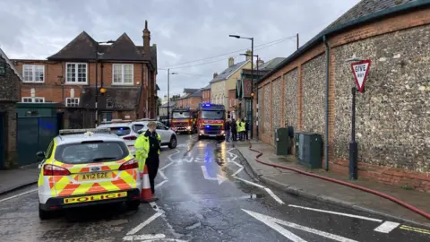 Luke Deal/BBC Police and fire crews outside Greene King brewery