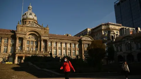 Getty Images A woman walks past Birmingham's town hall