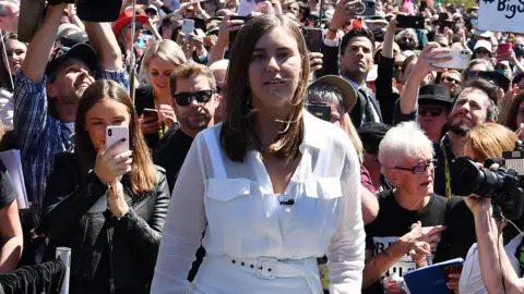 Getty Images Brittany Higgins in front of people at a protest earlier this year