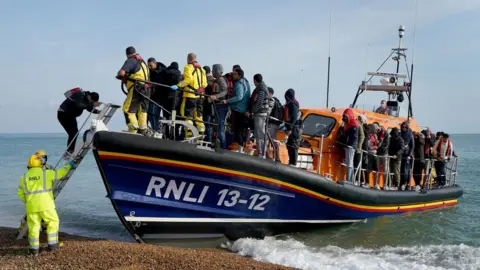 Gareth Fuller/PA Media A group of people thought to be migrants arrive in Dungeness, Kent, after being rescued in the Channel by the RNLI