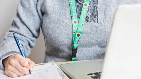  Carolina Jaramillo / Getty Images An adult wearing a Sunflower lanyard