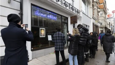 PA Media People gather outside a Vivienne Westwood store in London