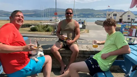 People drinking beer in the sun at Beaumaris, Anglesey