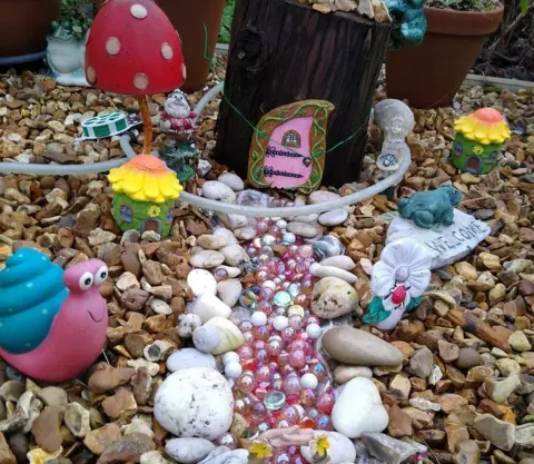 Barbara Betts Pink elf door with pink pebbles