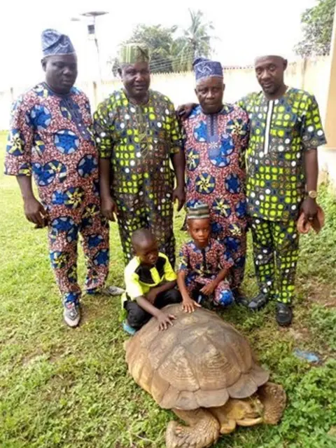 Peace Sojay and his family  Two children and men with the tortoise