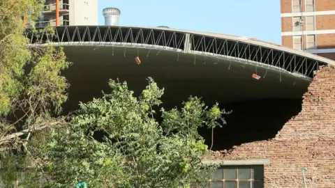 EPA The roof of a sports centre in the port city of Bahia Blanca seen partially collapsed after a storm.