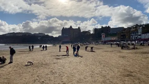 BBC People walking on the beach in Scarborough