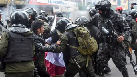 AFP Security forces scuffle with supporters of Bolivian ex-President Evo Morales during a protest in La Paz on 13 November, 2019