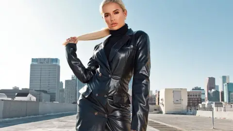 PrettyLittleThing Model Molly-Mae Hague standing in a tight leather jacket and turtleneck sweater on a rooftop in Los Angeles