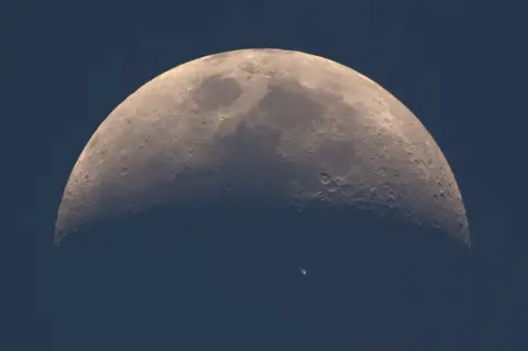 Dani Caxete The International Space Station (ISS) whizzes across the dusky face of the moon