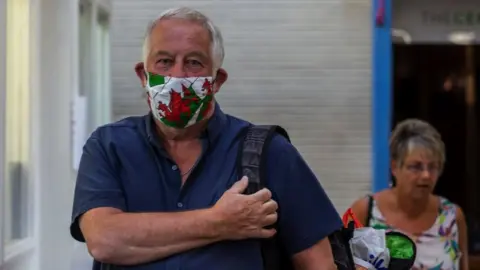 Getty Images man wears a Welsh red dragon face mask in Pontypridd indoor market on May 26, 2020 in, Pontypridd, Wales,