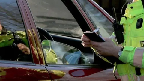 PA Media A policewoman stopping a driver