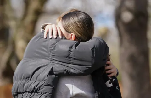 PA Media Beckton fire death: women hug