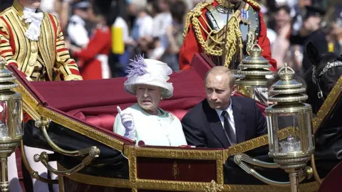 Getty Images Queen Elizabeth II and Vladimir Putin in a carriage in 2003