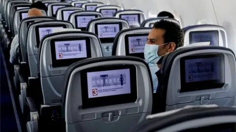 Reuters A man on a plane in a mask