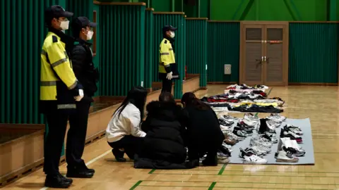 BBC/Danny Bull A group of survivors or relatives of victims pick out items that belonged to them or their loved ones