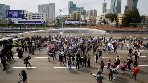 Reuters Israeli police used water cannon to disperse anti-government protesters blocking a major road in Tel Aviv, Israel (23 March 2023)